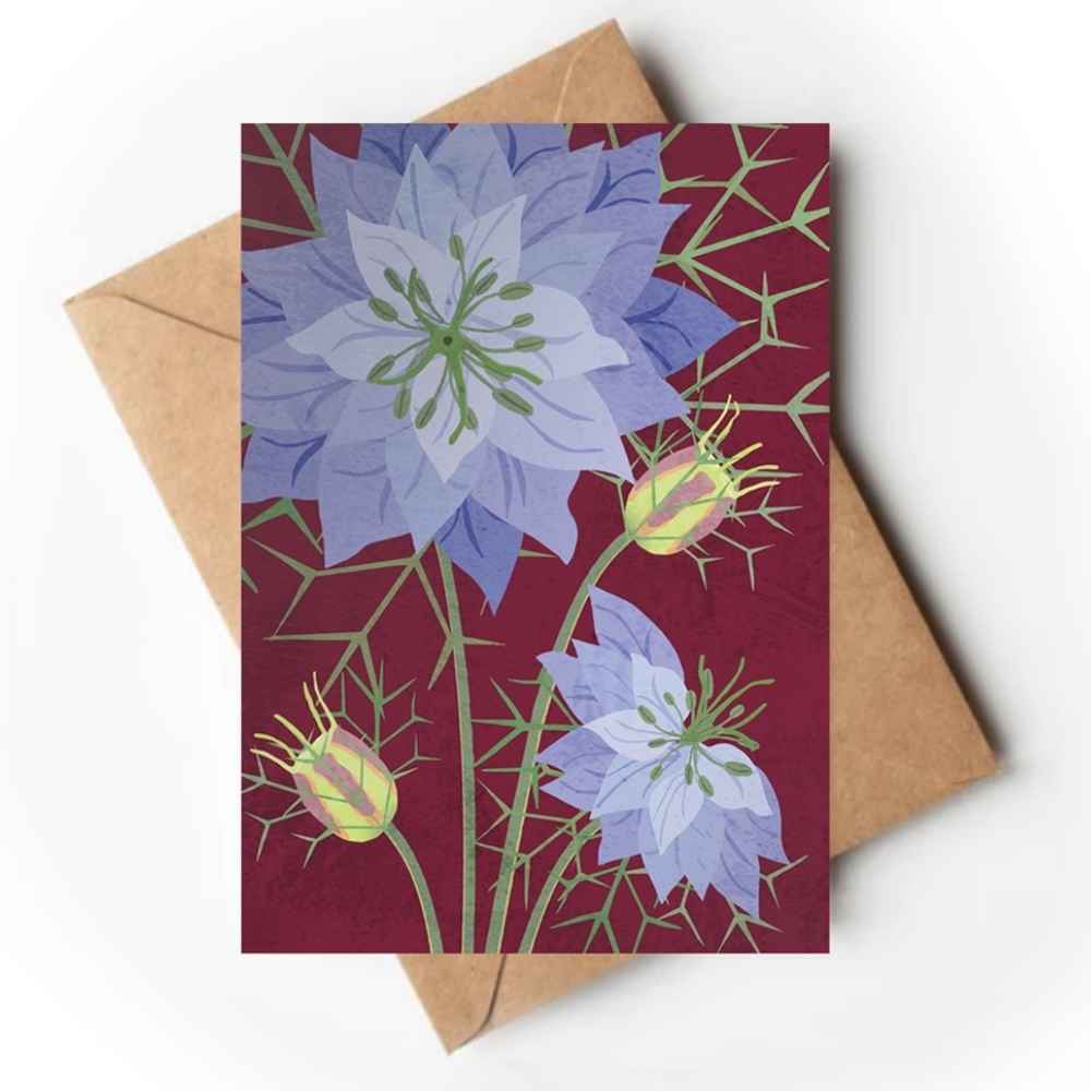 A rectangular art print or card featuring stylized blue-purple flowers and green stems on a deep burgundy background, placed on top of a brown kraft envelope against a light neutral backdrop.